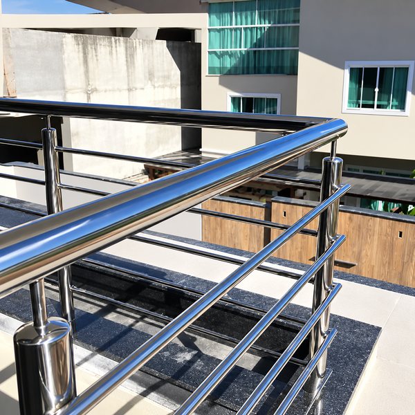 Corrimão e montantes de aço inox de um guarda-corpo, em área externa