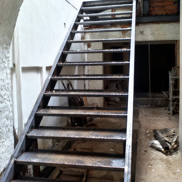 Escada de estrutura metálica recém-montada, ainda em obra